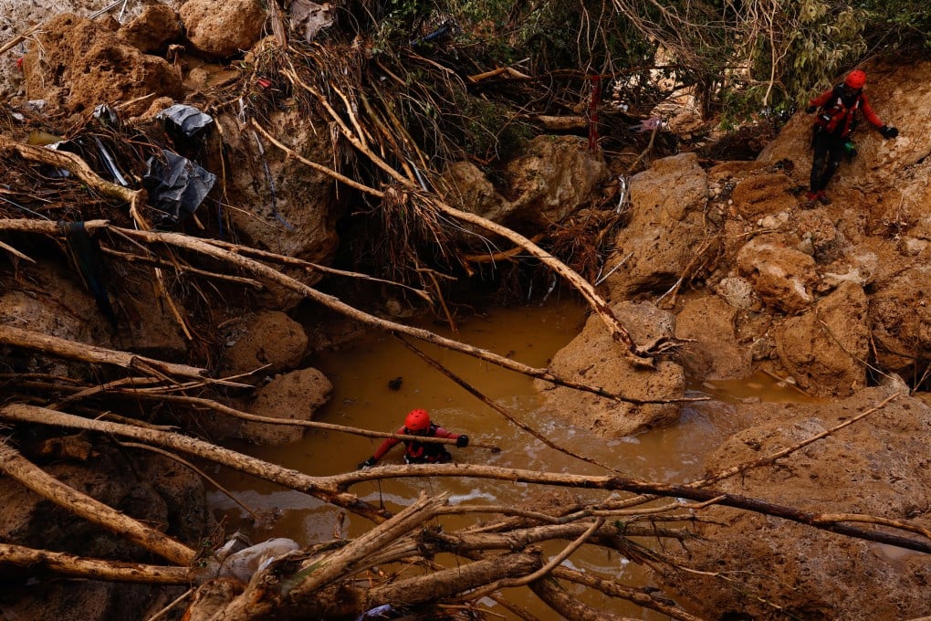 Members of a rescue team search for missing people near a river after heavy rains caused flooding in Letur, Spain. Photo: Reuters
