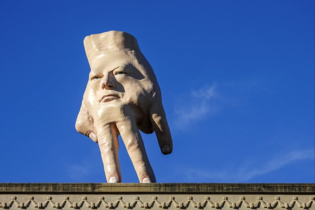 A 16-foot (almost 5 metres) hand sculpture named Quasi stands perched on its fingertips atop the roof of an art gallery in Wellington. Photo: AP