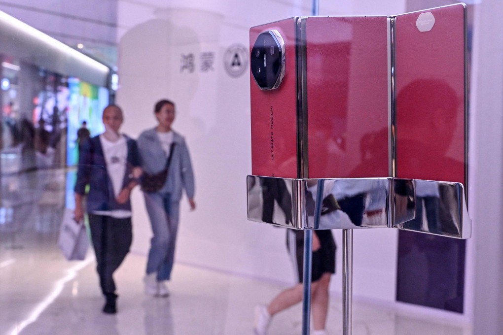 People walk past a Huawei Mate XT triple-folding phone displayed at a Huawei store in Beijing on September 10, 2024. Photo: AFP