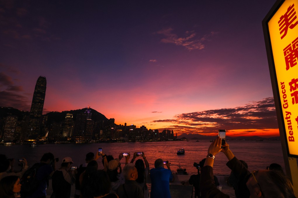 People admire the sunset skyline from the Tsim Sha Tsui promenade as Severe Tropical Storm Trami approaches the city under the No 1 typhoon signal on October 25. Photo: Nora Tam