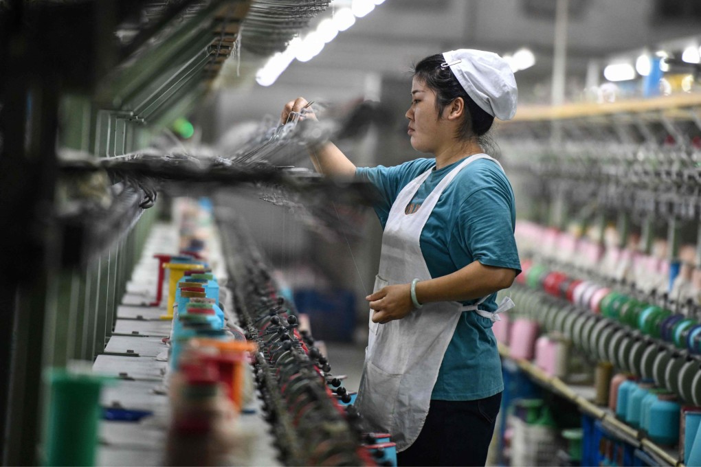 An employee works a textile factory that produces silk products in Fuyang in eastern China’s Anhui province. Photo: AFP