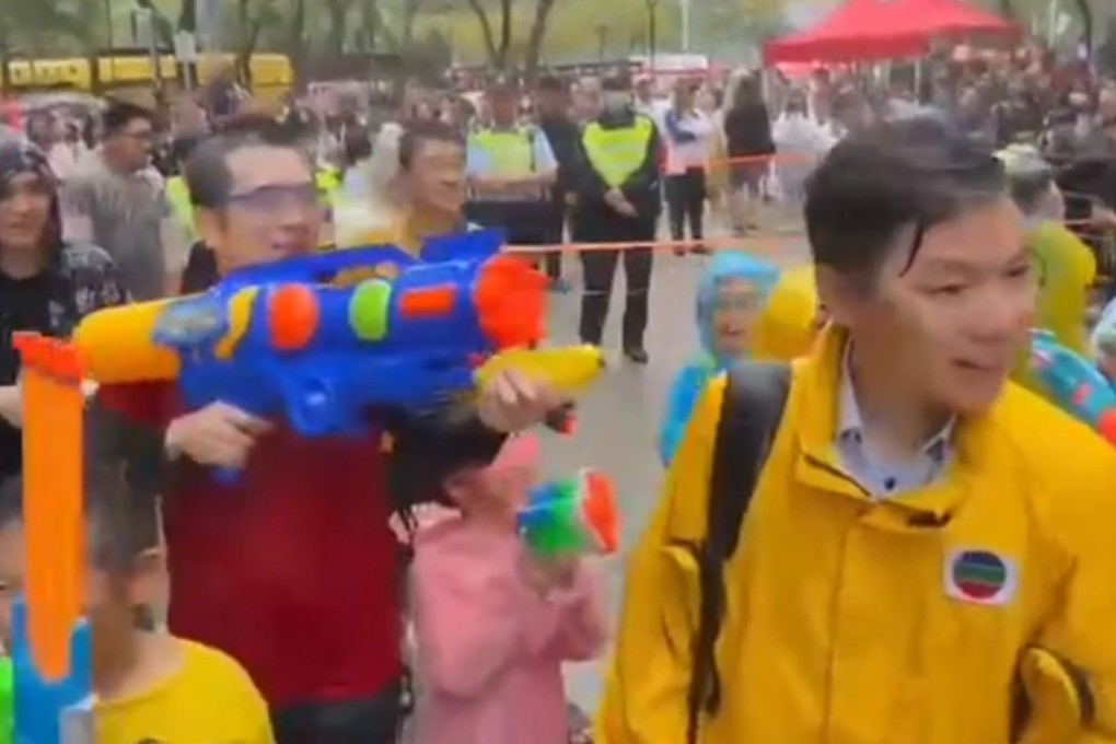 A screengrab of a video showing TVB reporter Timothy Li (right) smiling while being splashed by Tsang Wai-shing (red shirt) during the 2023 Songkran festival in Kowloon City. Photo: Handout