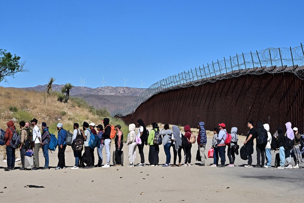 Migrants wait in line hoping for processing from Customs and Border Patrol agents after groups arrived at Jacumba Hot Springs, California. Photo: TNS
