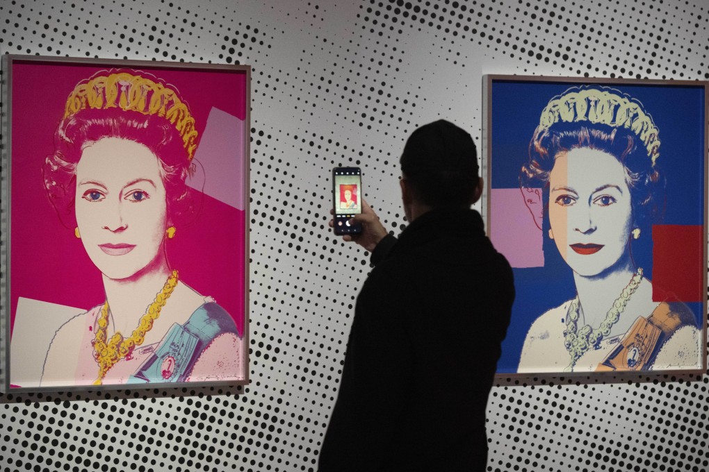 A man takes an image of a screen print on show in Apeldoorn, Netherlands, depicting Queen Elizabeth II, one in a series of 16 by Andy Warhol and similar to a work stolen from a gallery in Oisterwijk, Netherlands, early on November 1, 2024. Photo: AP