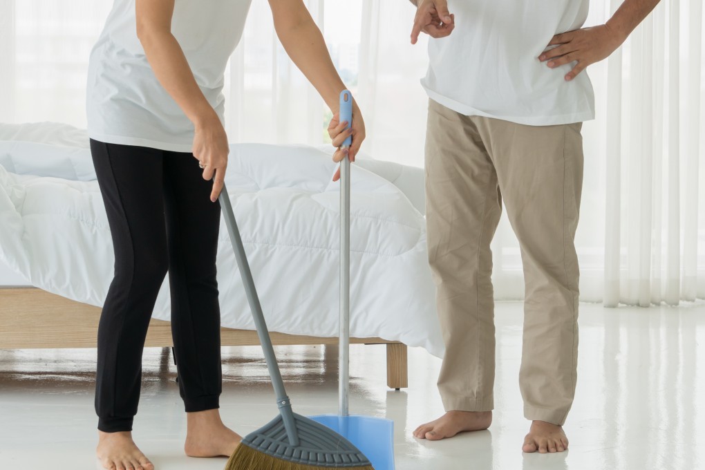 A woman cleaning a room with a man standing next to her. Photo: Shutterstock
