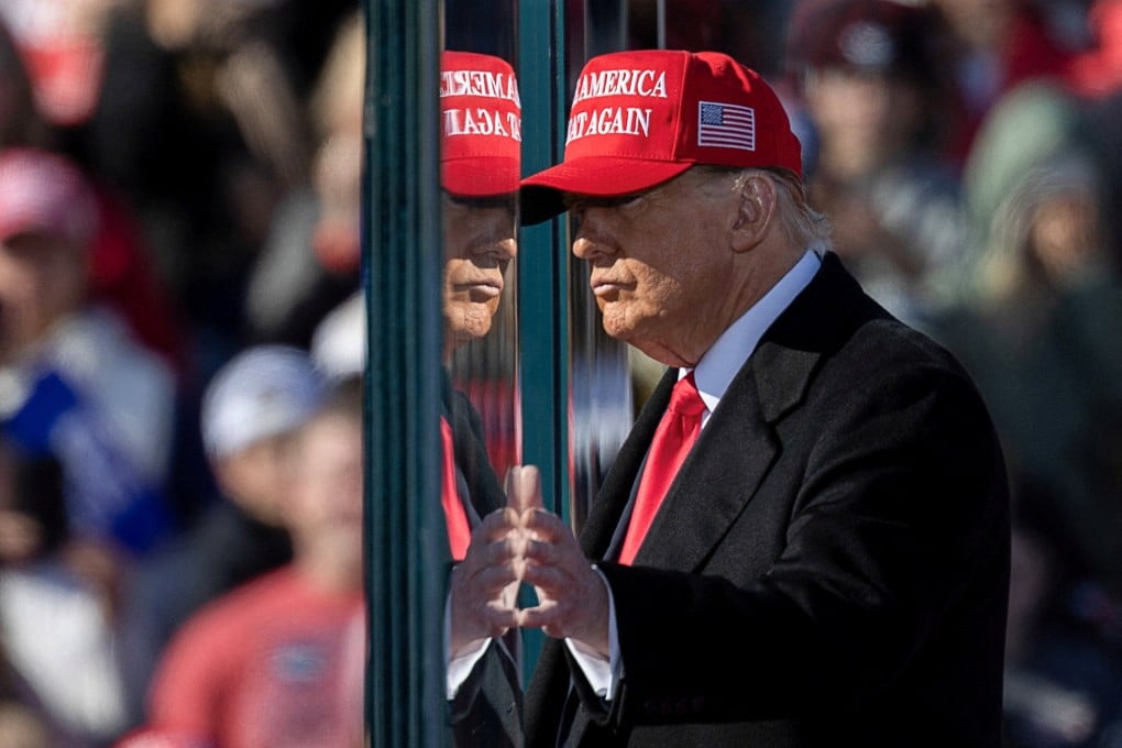 Donald Trump touches bulletproof glass surrounding him at a campaign rally, in Lititz, Pennsylvania. Photo: Reuters