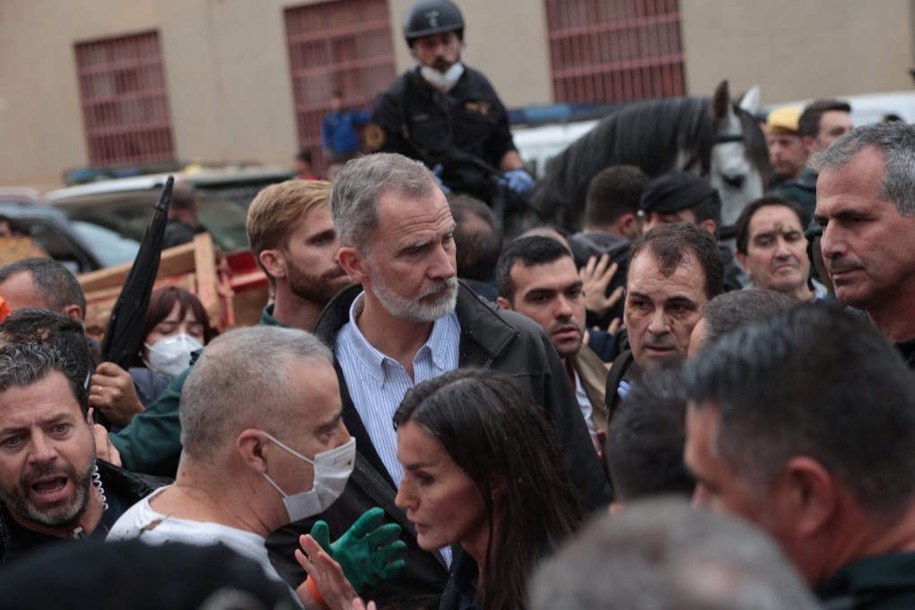 Spain’s King Felipe and Queen Letizia, centre, listen to the crowd after citizens threw mud at them during their visit to flood-stricken Paiporta, near Valencia, Spain on Sunday. Photo: Reuters