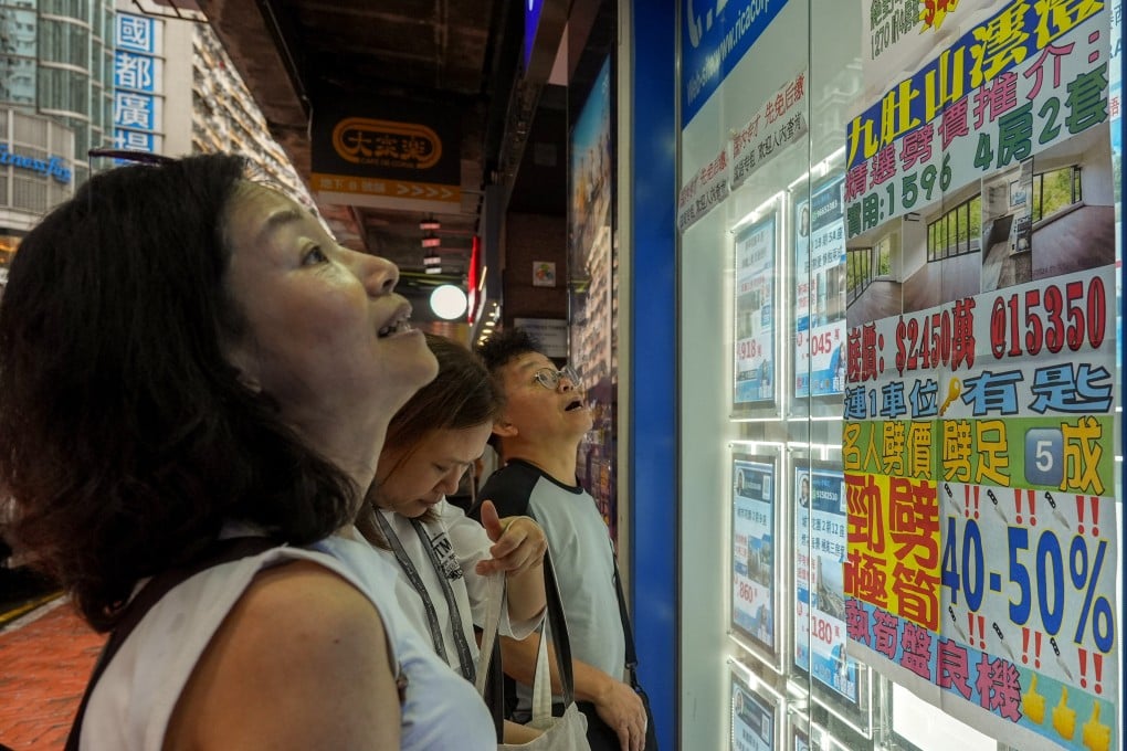 A poster in the window of a real estate agency in Fortress Hill, Hong Kong, shows deeply discounted house prices, on July 29. Photo: Eugene Lee