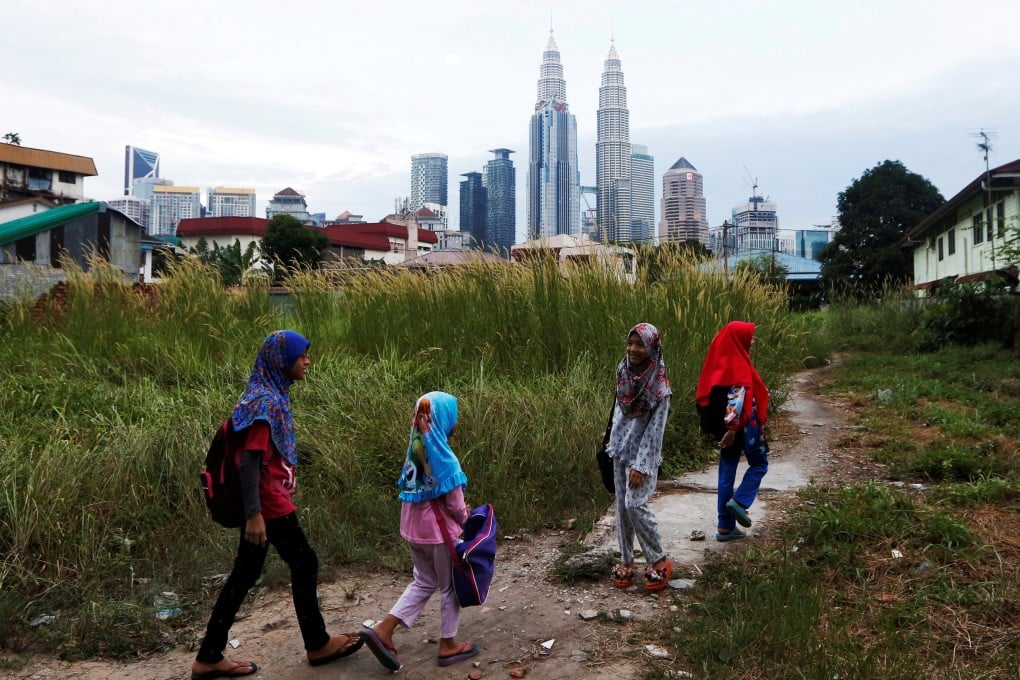 Girls make their way home after school in Kuala Lumpur, Malaysia. Photo: Reuters