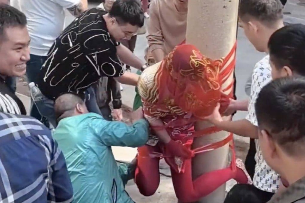 A still from a viral Chinese social media video of a woman being tied to a lamppost by men during a Chinese wedding hazing ritual. Photo: Weibo