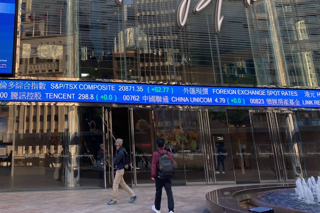 People walking outside the Exchange Square in Central, Hong Kong with screens showing index and stock prices in January 2024. Photo: Li Jiaxing