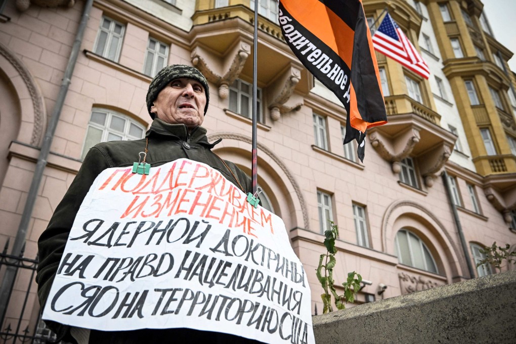 An activist holds a single-person picket in front of the US embassy in central Moscow on November 5, with a poster reading “We Support Changing the Nuclear Doctrine to Allowing to Retarget Nuclear Weapons at the United States”. Photo: AFP