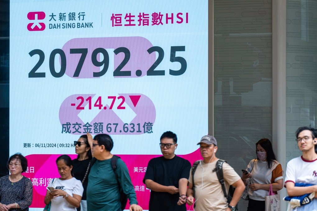 Pedestrians walk past an electronic screen displaying the Hang Seng Index on the US presidential election day in Central. Photo: AP