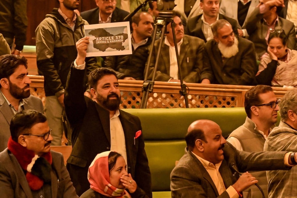 A member of Jammu and Kashmir’s legislative assembly holds a poster in support of a resolution to restore the state’s special status during a session in Srinagar on November 6. Photo: AFP