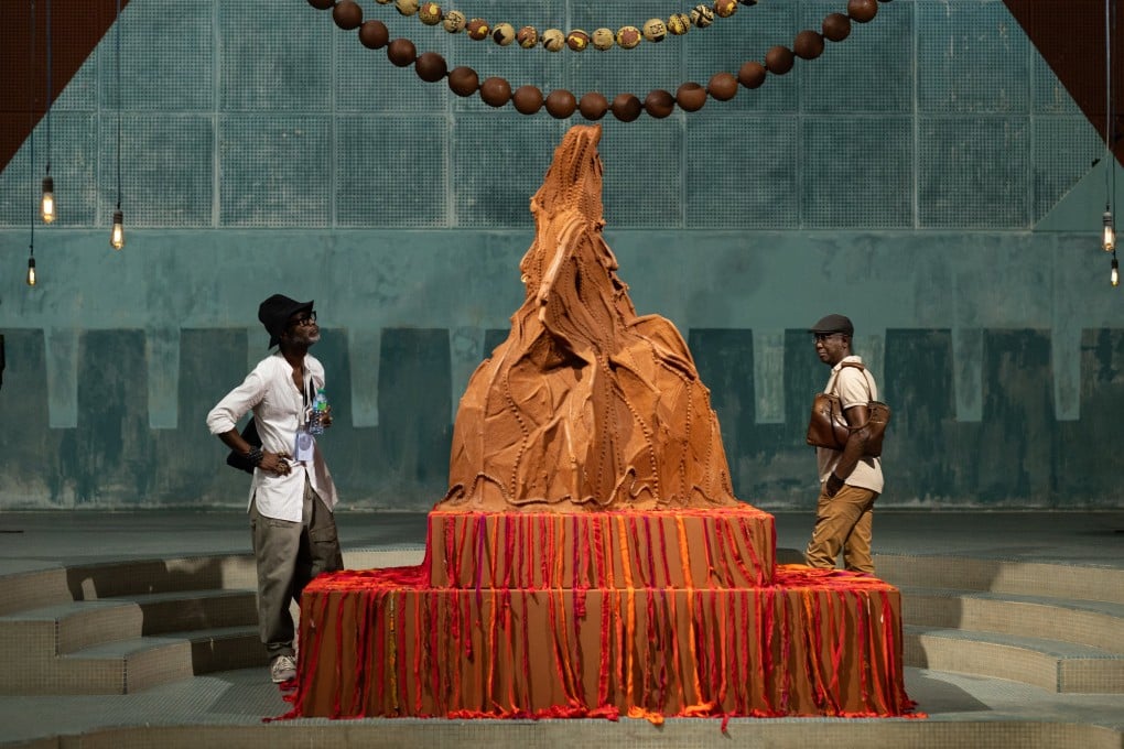 Visitors to the 15th Biennale of Contemporary African Art in Dakar, Senegal, view part of an installation called A Palace in Pieces including Mountain Mama by Kenyan artist Wangechi Mutu. The exhibition’s theme is “The Wake”. Photo: EPA-EFE