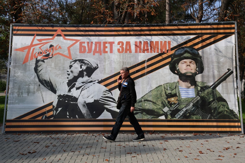 A man walks past a banner reading “Victory will be ours!” in the settlement of Sovetsky, Crimea, in October. Photo: Reuters