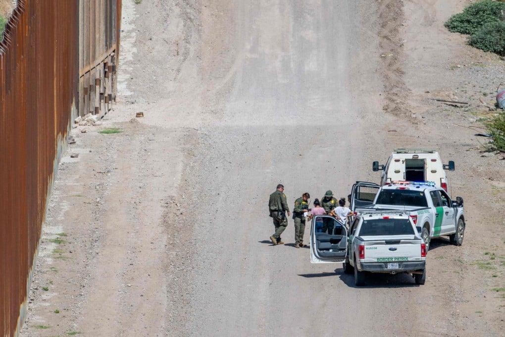 A group of migrants are apprehended by border officers after crossing into the US earlier this year. Photo: AFP
