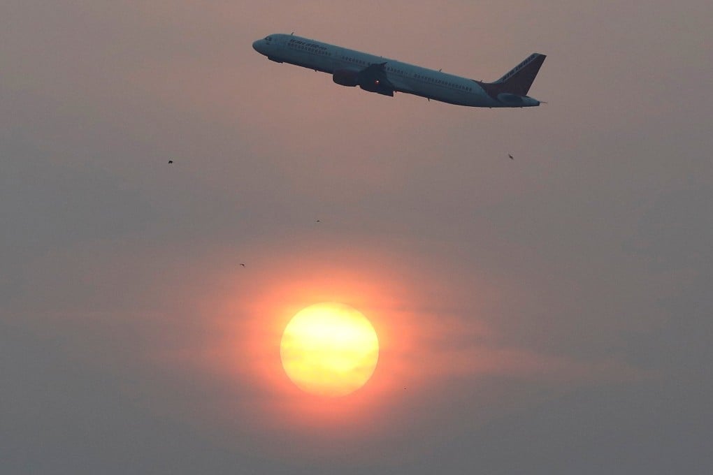 An Air India plane passes the sun after take-off in Ahmedabad, India. Photo: Reuters