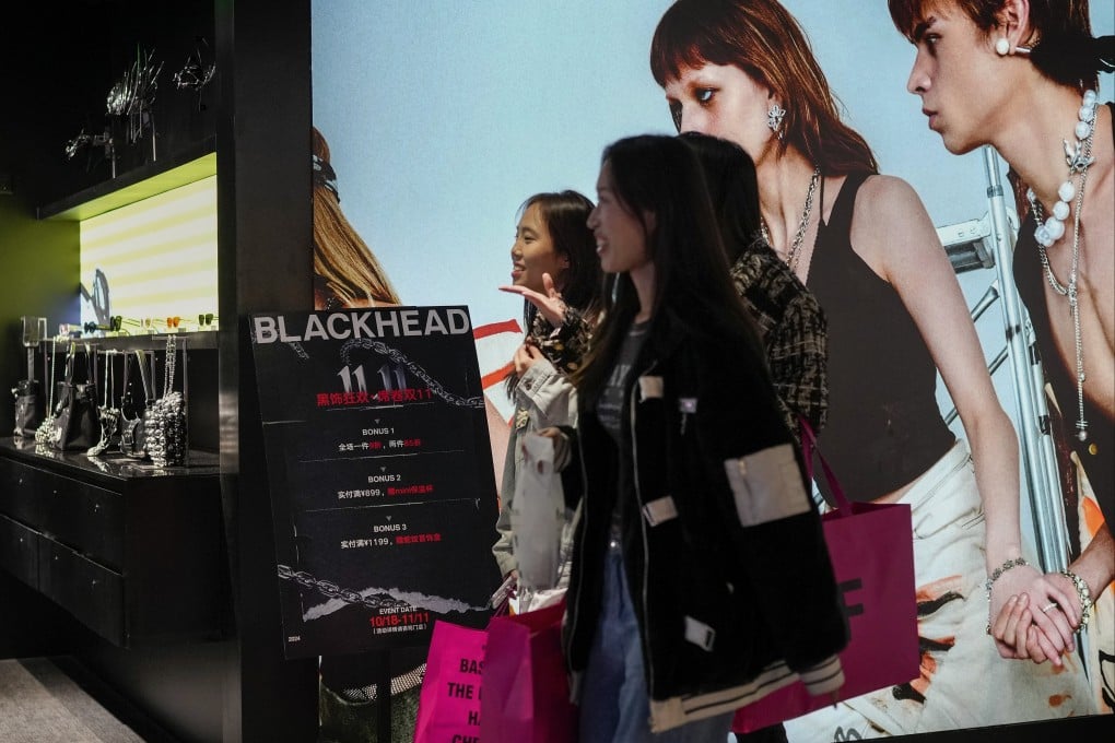Women walk inside a fashion accessories store displaying Singles’ Day discounts at a Beijing shopping centre on November 11, 2024. Photo: AP