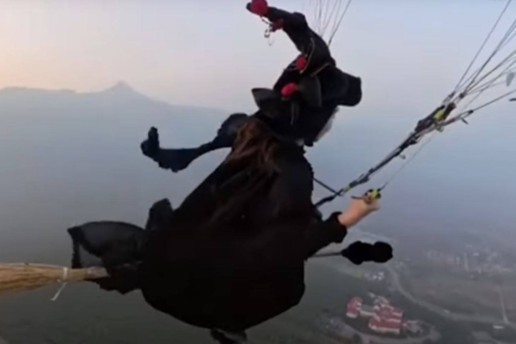 A woman went paragliding in central China’s Henan province dressed as a witch, complete with broomstick. Photo: Newsflare