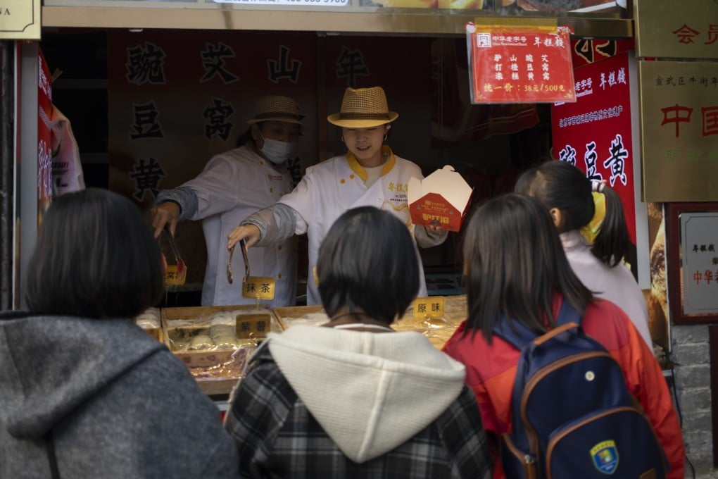 Vendors offer desserts to pedestrians at a store in Beijing. Photo: EPA-EFE