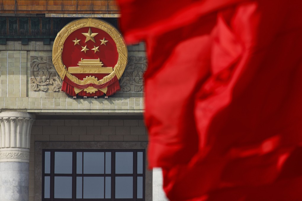 A red flag flutters near China’s national emblem outside the Great Hall of the People in Beijing. Photo: AP