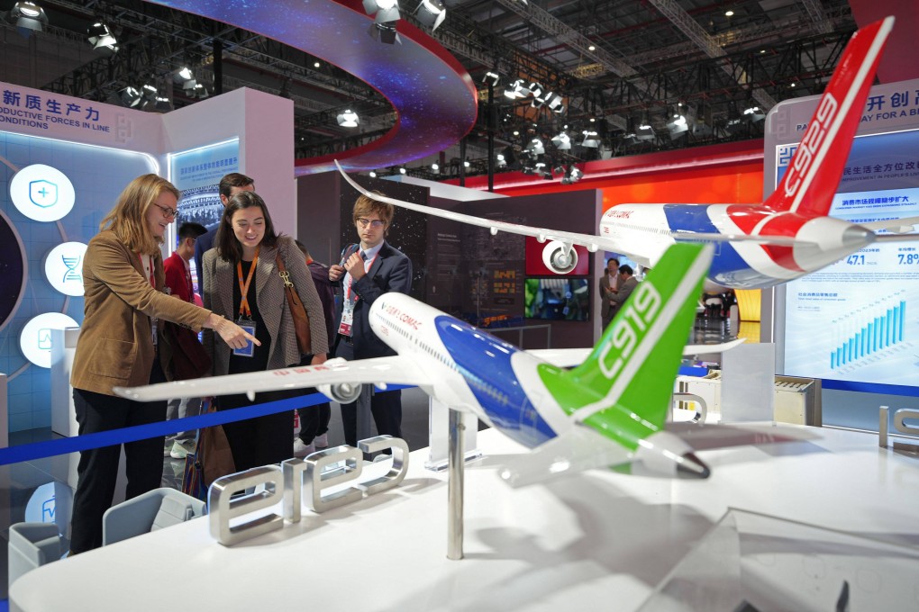 Visitors look at models of China’s domestically made passenger jets, the C919 and the planned C929, at the China International Import Expo in Shanghai on November 5. Photo: AFP