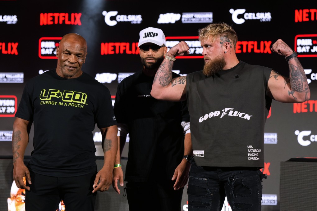 Mike Tyson, left, and Jake Paul, right, pose for photos during a news conference promoting their coming boxing bout. Photo: AP