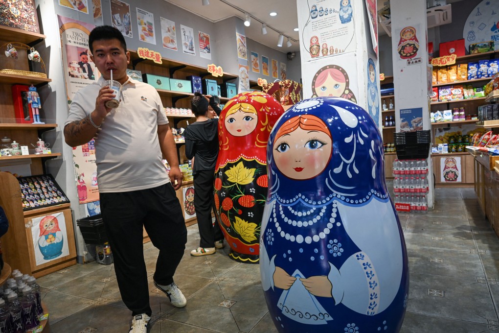 A man walks past traditional Russian Matryoshka dolls at a store where Russian products are sold in Beijing. Photo: AFP