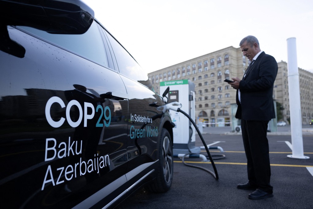 A driver uses his mobile phone at the electric charging station as Baku city hosts the United Nations Climate Change Conference (Cop29), in Azerbaijan, on November 14. Photo: Reuters