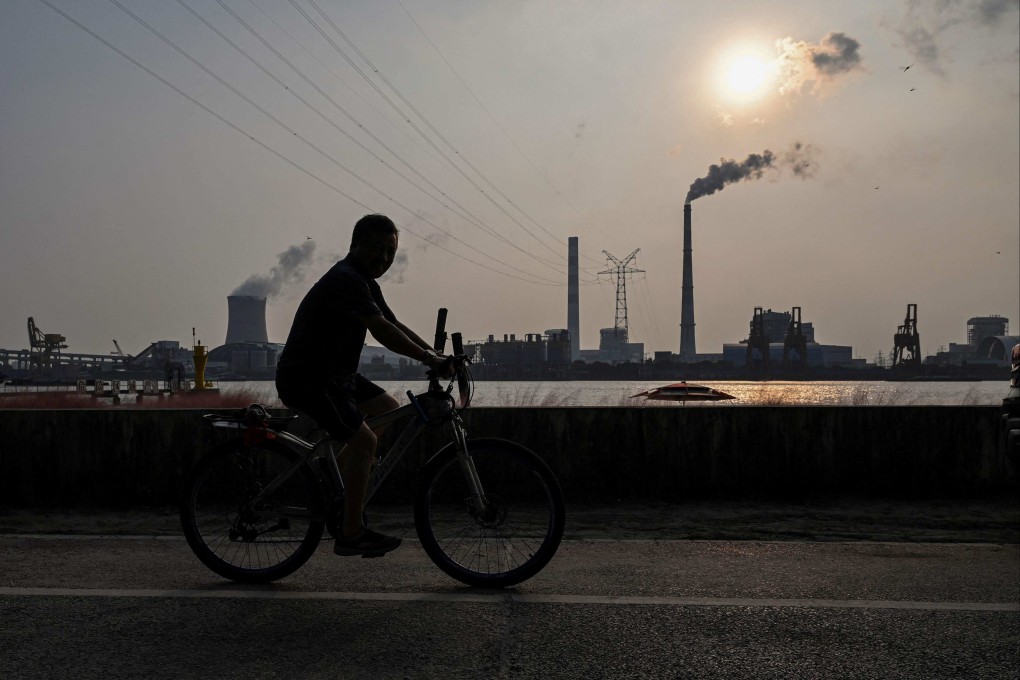A man rides a bicycle near a power station in Shanghai. File photo: AFP