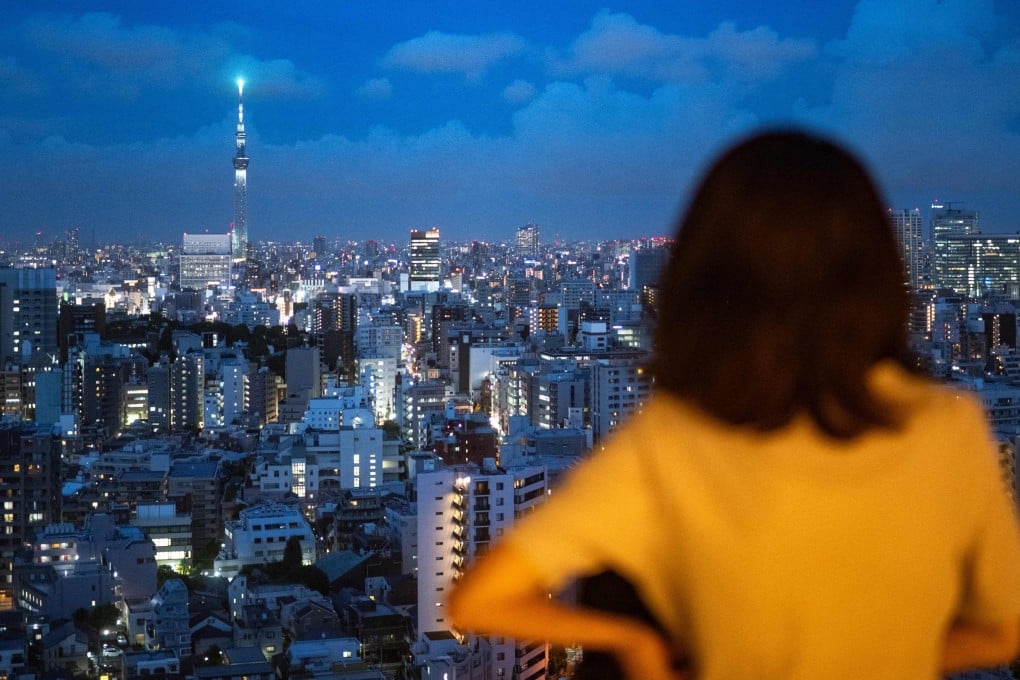 A woman looks out at the Tokyo skyline. Photo: AFP
