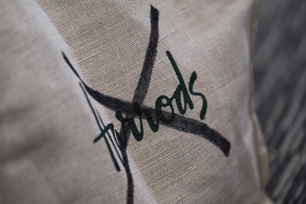A Harrods tote bag with the brand name crossed out is seen at a press conference in London in October. Photo: AP