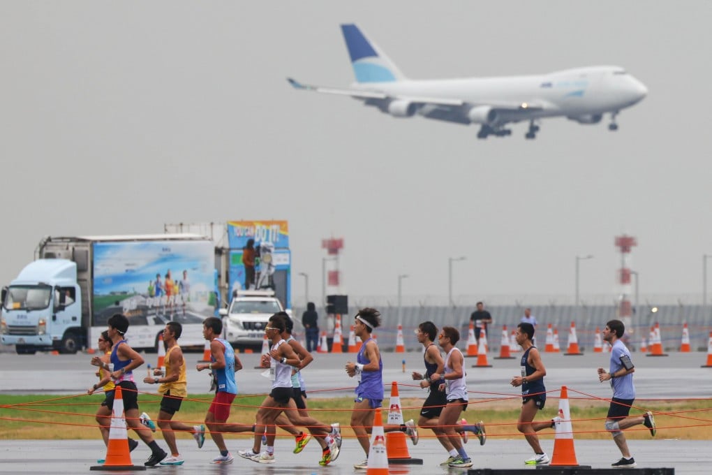 A plane comes into land as runners compete in the Standard Chartered Hong Kong Marathon10km race on the third runway at the city’s international airport. Photo: Eugene Lee