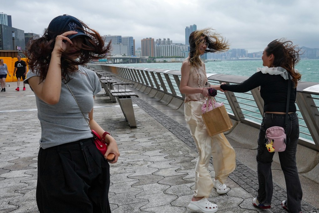 Tourists take pictures in Tsim Sha Tsui while the number 8 warning signal was in effect last week. Photo: May Tse