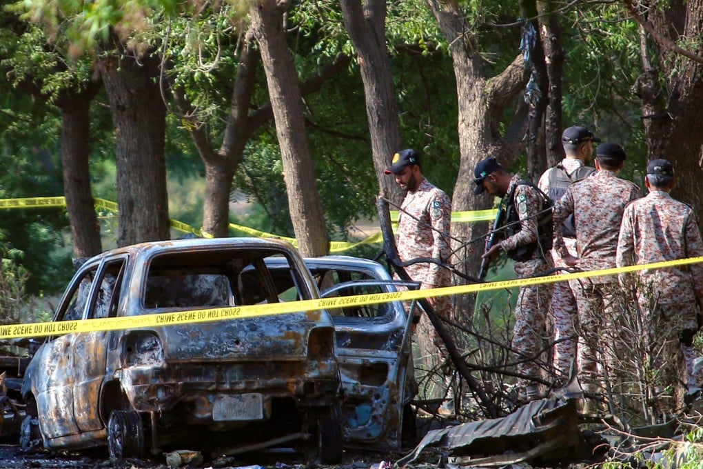 Security officials inspect the site of the suicide attack that killed two Chinese citizens in Karachi. Photo: EPA-EFE