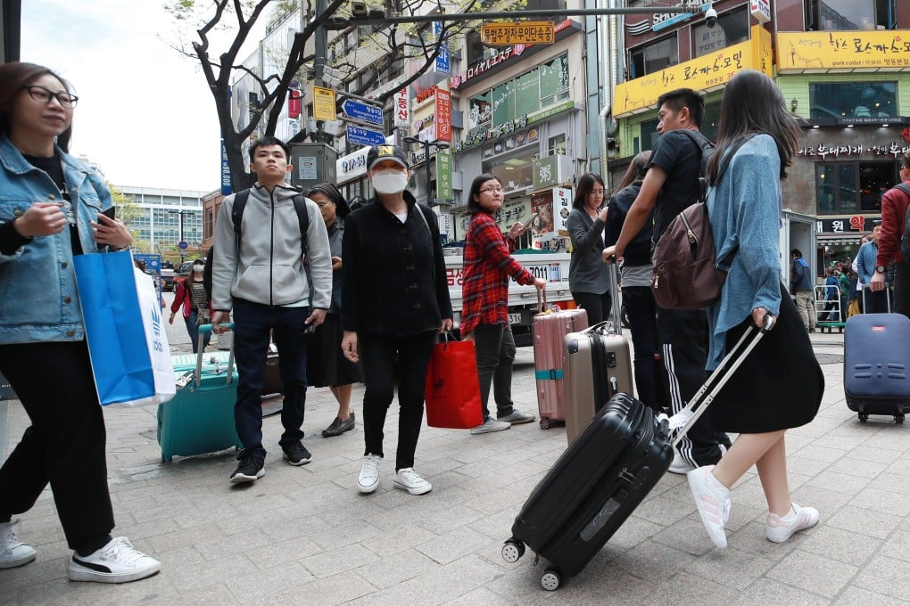 Chinese tourists carry their baggage on Myeongdong Street in downtown Seoul, South Korea. Photo: EPA-EFE/Yonhap