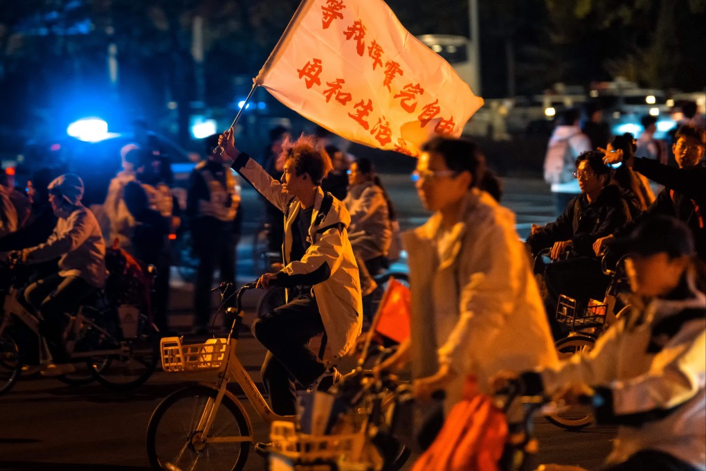 A cyclist waves a flag saying “I will reach a compromise with life after I squander my freedom”, as students ride rental bicycles in Zhengzhou city, Henan province, on November 8. Photo: EPA-EFE