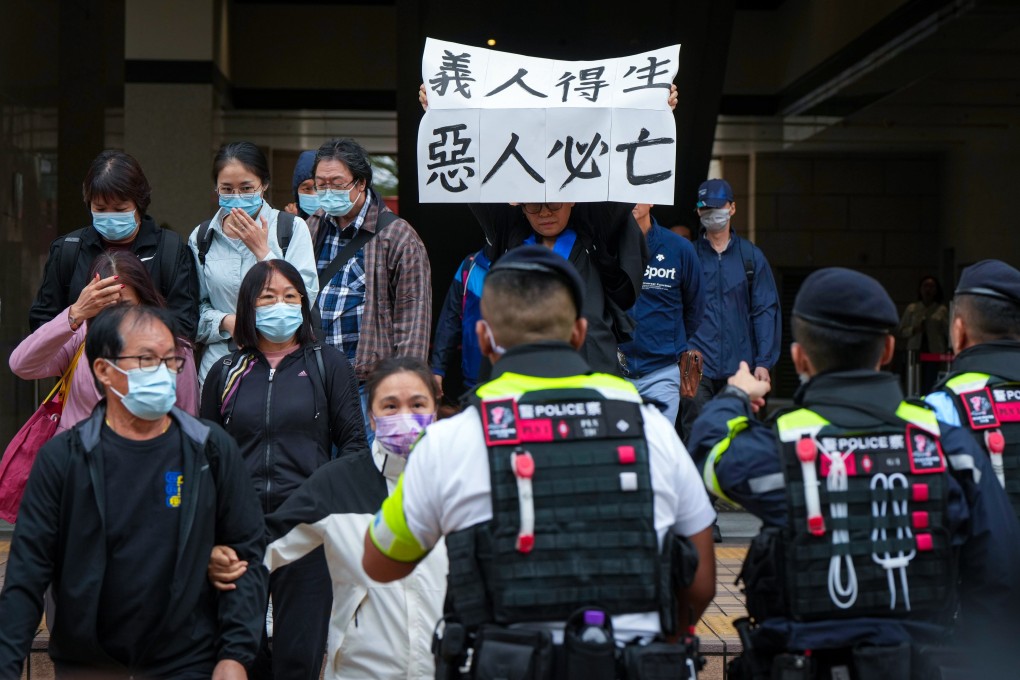 Elsa Wu, foster mother of defendant  Hendrick Lui, holds up a banner reading “The righteous shall live; the wicked shall perish”, ahead of the sentencing hearing. Photo: Sam Tsang