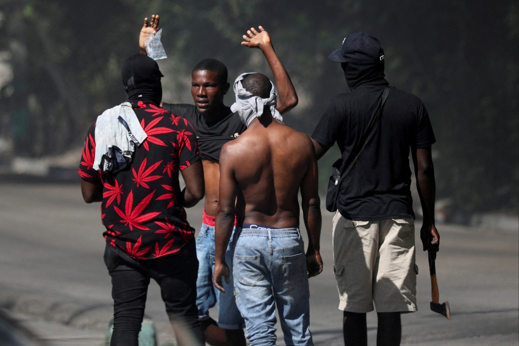 Residents question a person who is not from the neighbourhood after an attempted overnight attack by gangs. Photo: Reuters