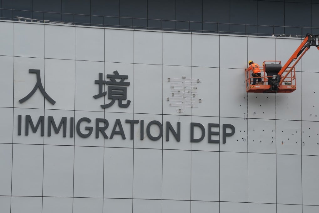 A worker installs the name of the new Immigration Tower in Tseung Kwan O, on January 23. Photo: Elson Li