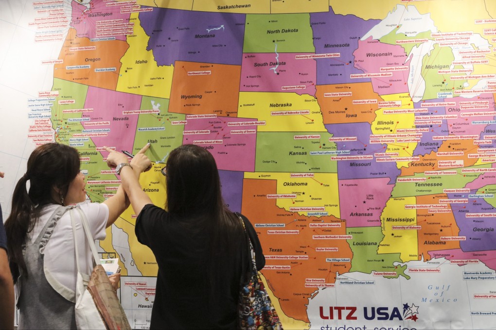 People attending an education expo in Hong Kong look at a map of universities in the US. Photo: Felix Wong
