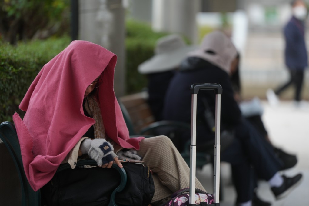 A woman covers up to protect against cold weather in Sha Tin. Photo: Sam Tsang