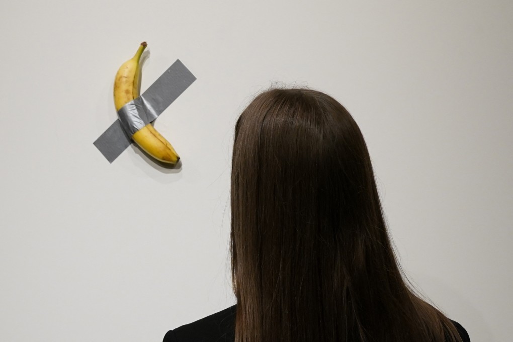 A woman looks at Italian visual artist Maurizio Cattelan’s duct-taped Banana entitled Comedian during a  preview ahead of its auction for US$6.2 million at Sotheby’s in New York, on November 20, 2024. Photo: AFP