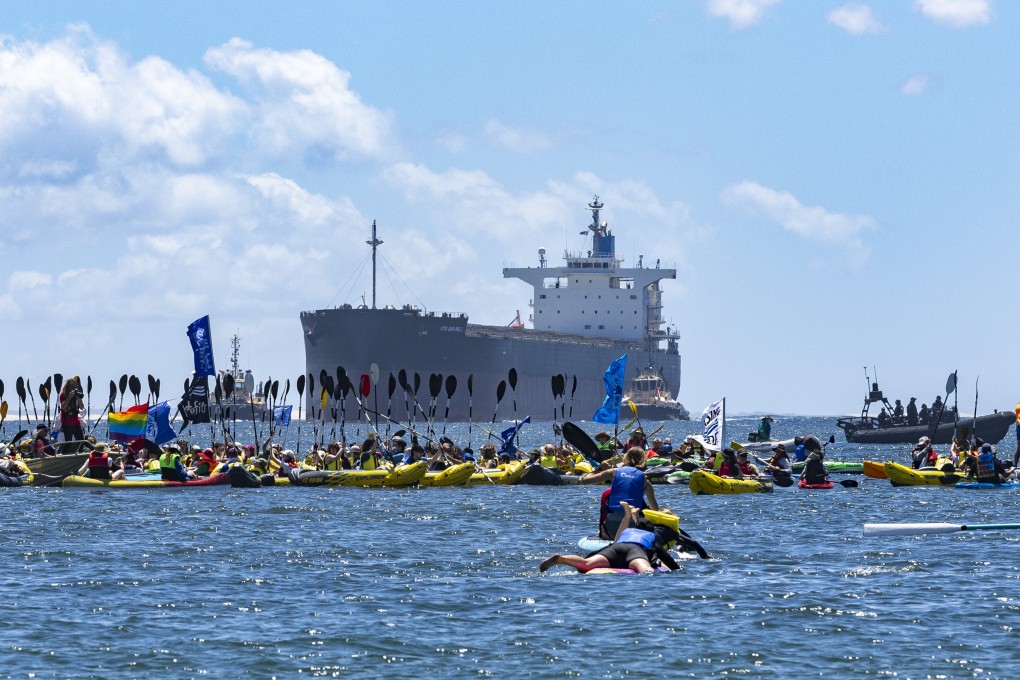 Protesters gather at the mouth of the harbour during a coal export demonstration at Nobbys Beach. Photo: DPA