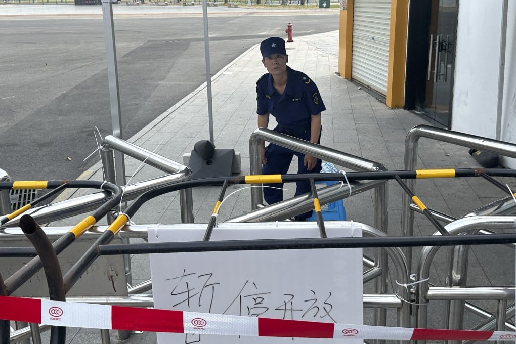 A security guard keeps watch from behind barricades near the entrance to a sports centre in Zhuhai, China, where 35 people were killed when a car was driven into a crowd of people on November 11. Photo: AP