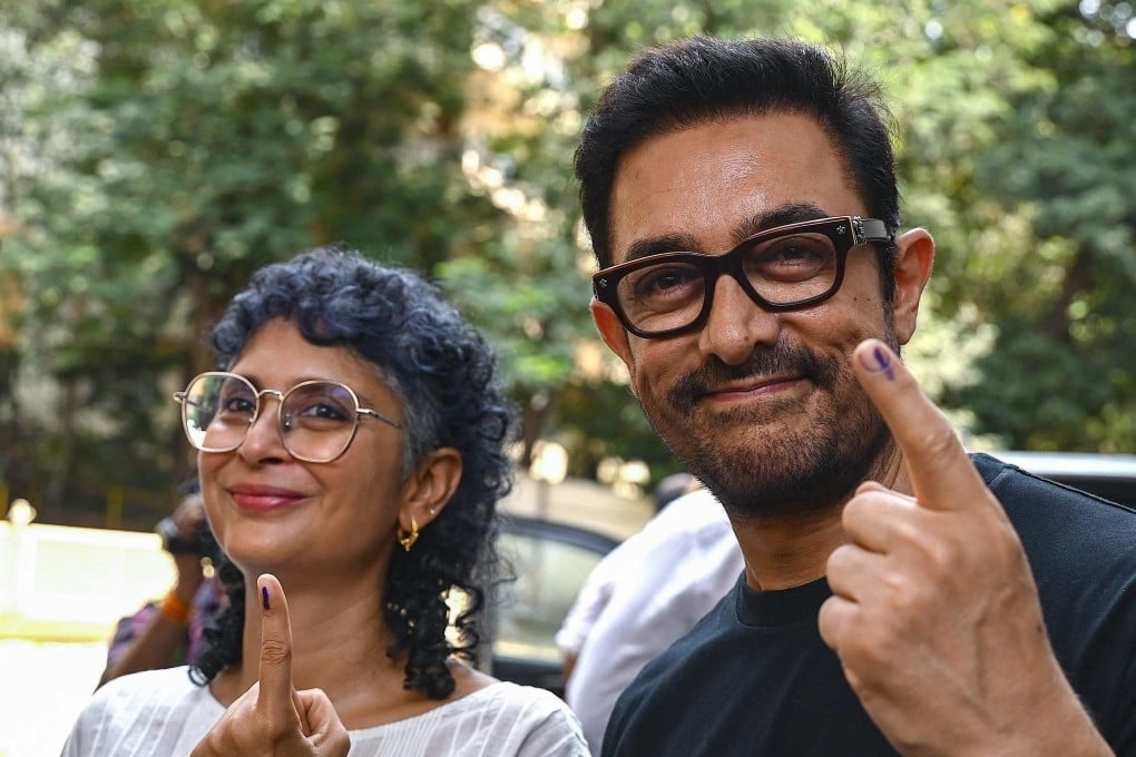 Bollywood actor Aamir Khan and director Kiran Rao (left)) display ink marked fingers after casting their votes at a polling station on May 20. Photo: AFP