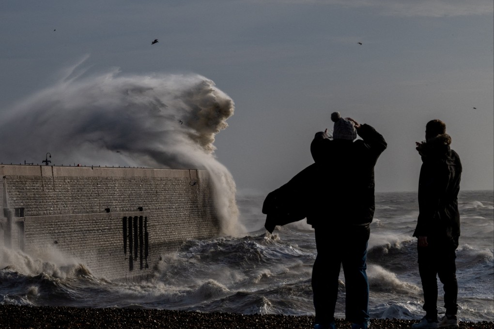 Locals look on as high winds from Storm Bert cause waves to crash over the harbour arm in Folkestone, Britain. Photo: Reuters