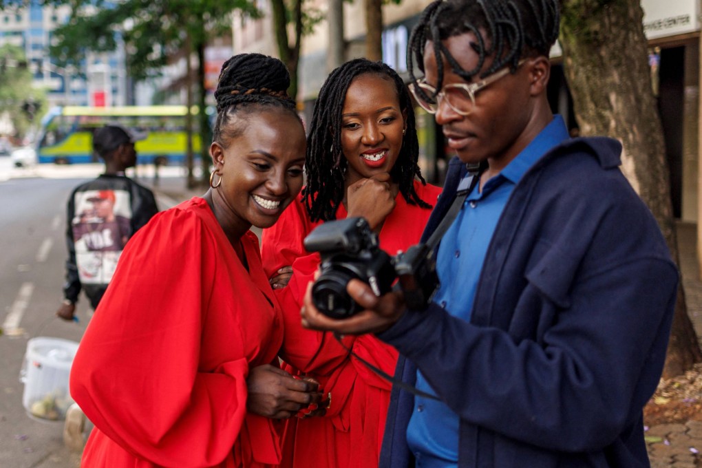 Two women review photos of them taken by a street photographer in central Nairobi. Scenes of violent protest in the Kenyan capital have been replaced with those of such photographers and online content creators. Photo: AFP