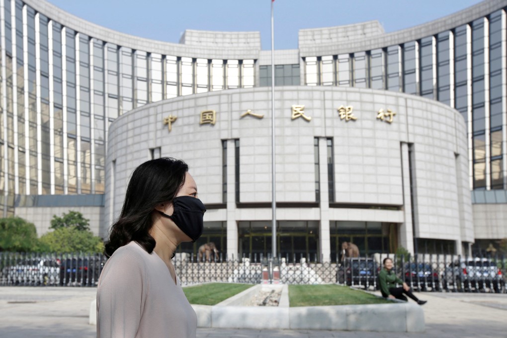 A woman walks past the headquarters of the People’s Bank of China in Beijing. Photo: Reuters